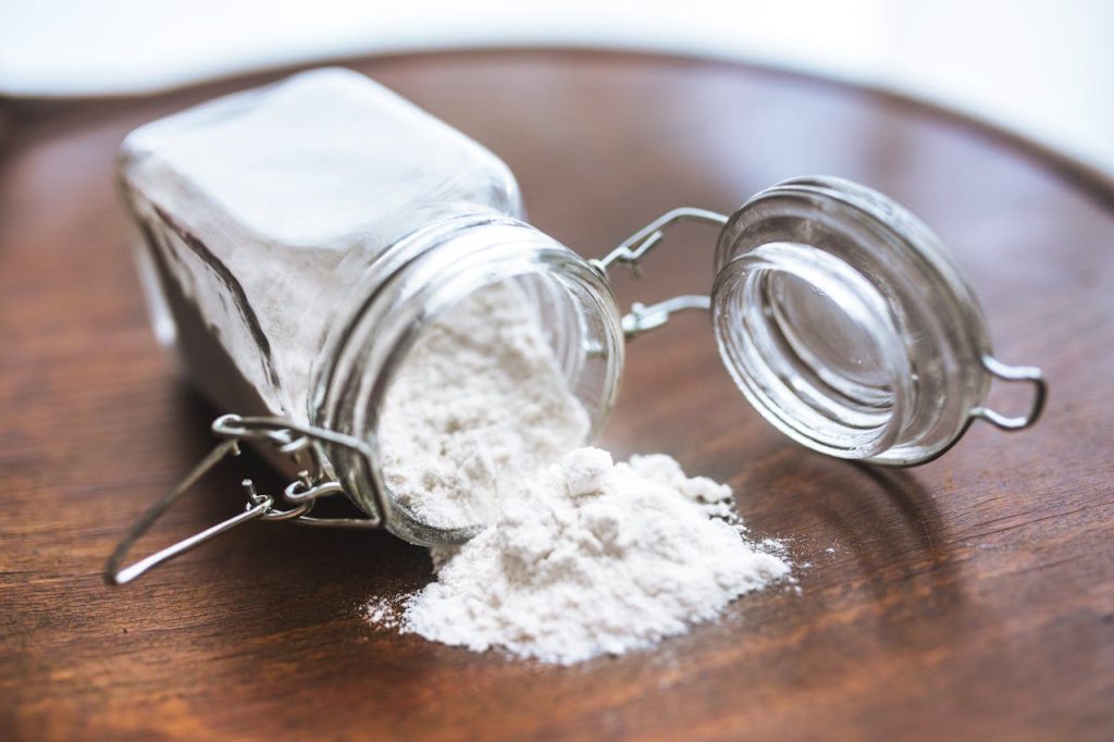 baking soda in a jar spilled over table